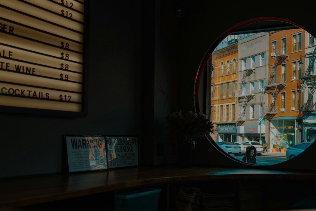 Editing desk covered with printed photo contact sheets overlooking a city window